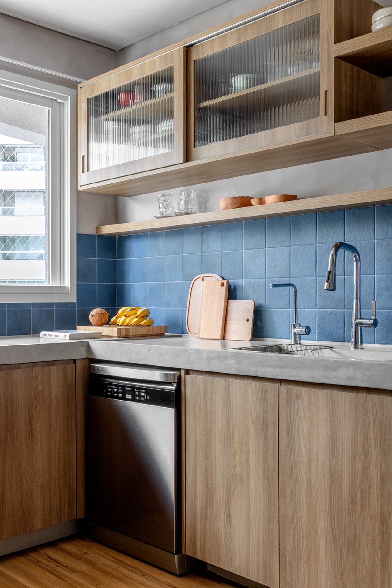 Cozinha com backsplash de cerâmica azul quadrada com armários em madeira natural