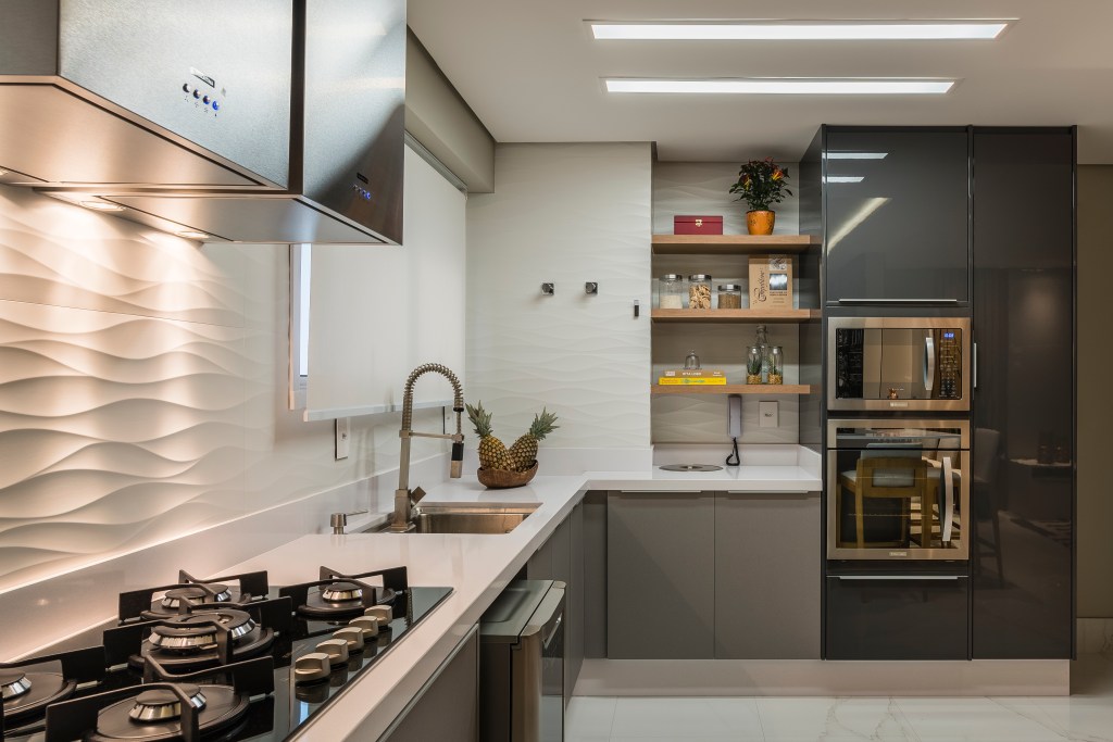 Cozinha com backsplash de porcelanato 3D com textura ondulada e iluminação realçando os relevos