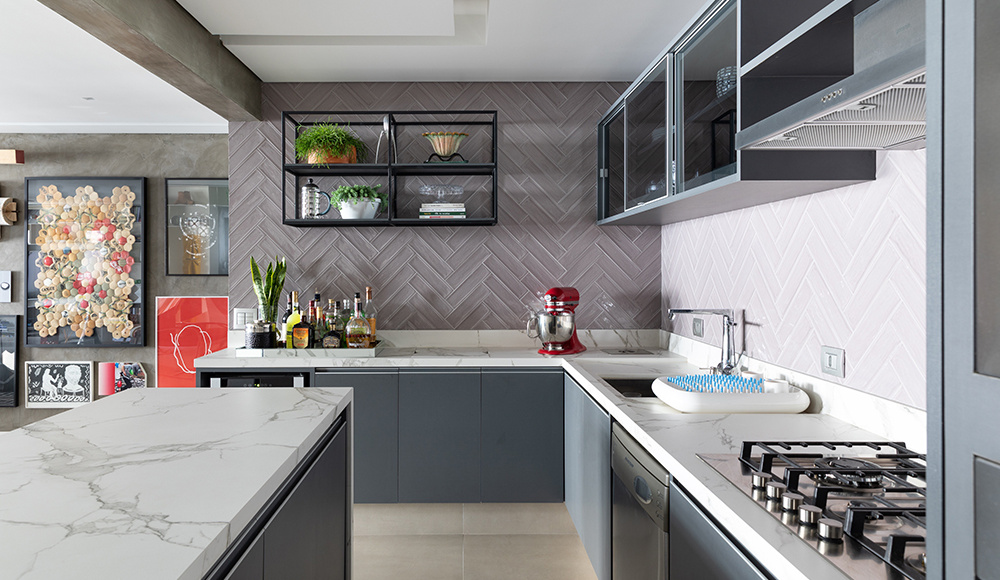 Cozinha em L com backsplash em paginação espinha de peixe em tons de cinza