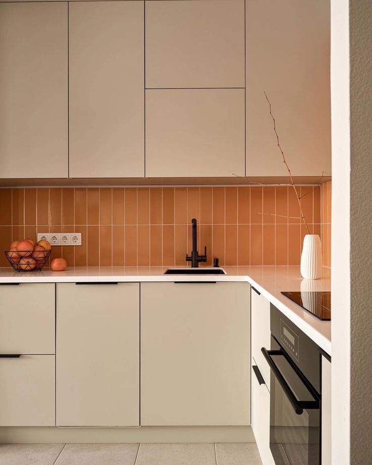 cozinha com revestimento backsplash ceramico na cor apricot crush com marcenaria na cor beige e t...