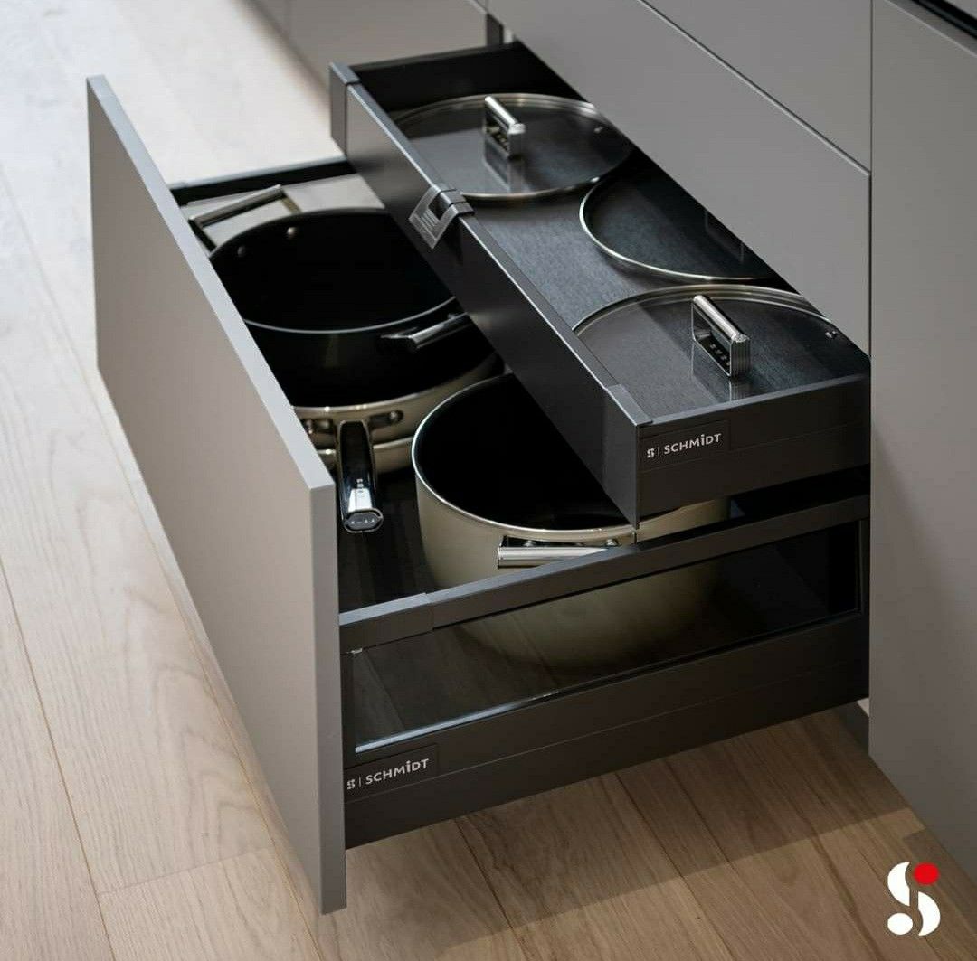 Gaveta oculta guardando as tampas de uma panela inserida dentro de um gavetão maior onde as pane...