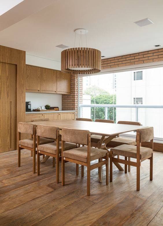 Living com piso de madeira de demolição em réguas largas no mesmo tom da madeira dos moveis