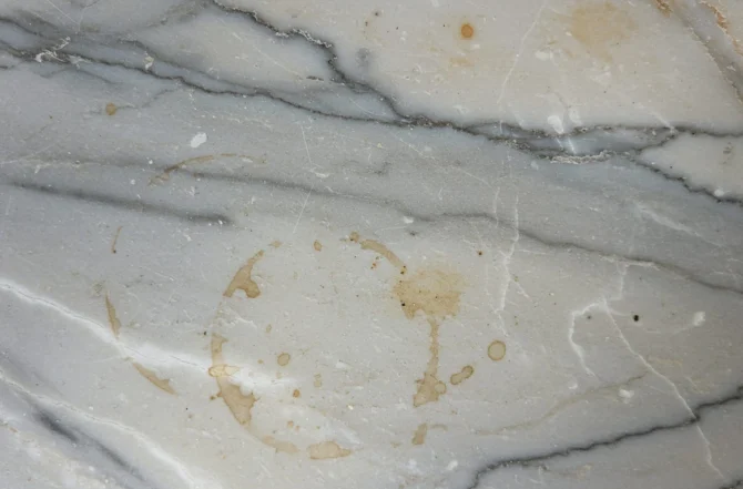 Mancha de café em mármore branco mostrando a porosidade e absorção da pedra